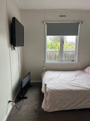 WarraneJennifer的一间卧室设有一张床、一台电视和一个窗口。