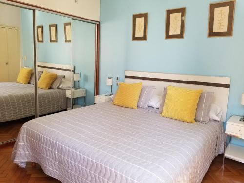 布宜诺斯艾利斯Corazón Porteño的一间卧室配有一张带黄色枕头的大床