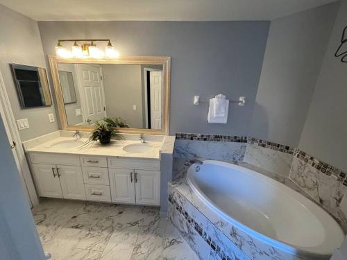 奥兰多Beautiful Modern 3 BR House - Downtown Orlando的带浴缸、两个盥洗盆和镜子的浴室