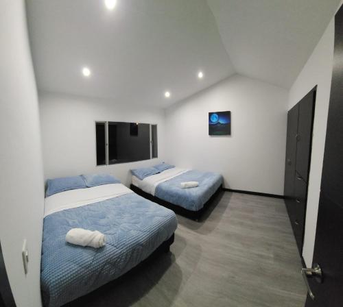 波哥大Casa Chimenea a 5 minutos del Aeropuerto的一间带两张床和电视的卧室