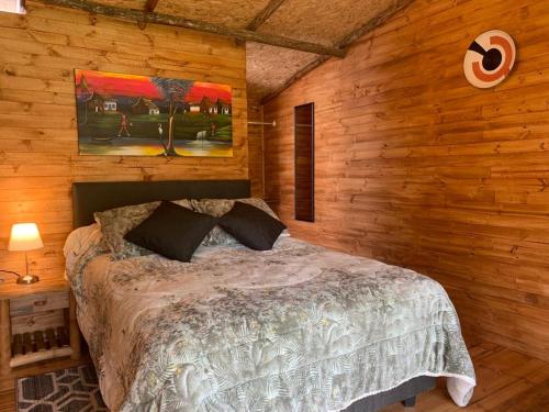 索波Hotel Cerro Fuerte的卧室配有木墙内的一张床