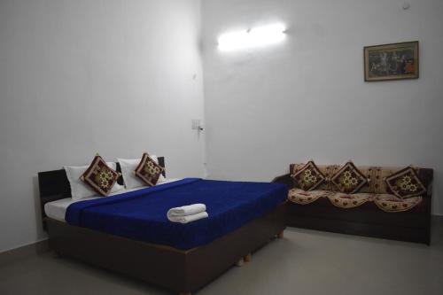 阿拉哈巴德BAGEECHA VILLA的一间卧室配有一张带蓝色床单和枕头的床。