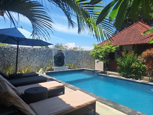 蓝梦岛瓦克图民宿的一个带庭院家具和遮阳伞的游泳池