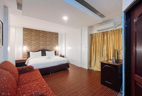 安吉利斯RedDoorz at Diamond Spring Hotel Angeles City的酒店客房,配有床和沙发