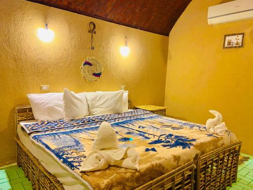 阿布辛贝Kabara Nubian House的一间卧室,配有一张带两顶帽子的床