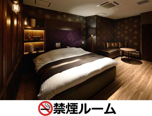 名古屋Hotel LALA - Kitashiga - (Adult Only)的一间卧室配有一张大床和一张书桌