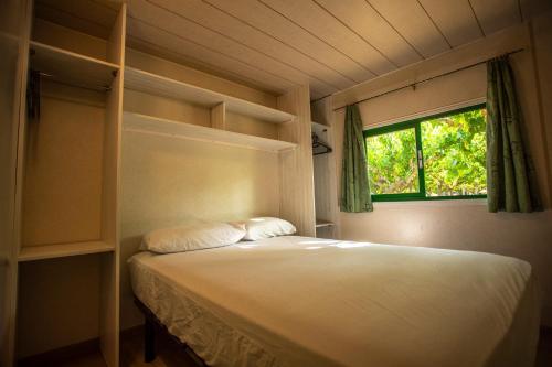 托里代巴拉Camping Clarà的一间卧室设有一张床和一个窗口