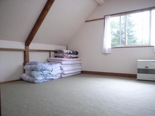 猪苗代町Cottage All Resort Service / Vacation STAY 8407的阁楼间配有一堆毯子