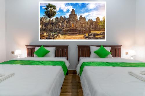 暹粒The Khmer House Villas的墙上画画的房间里设有两张床