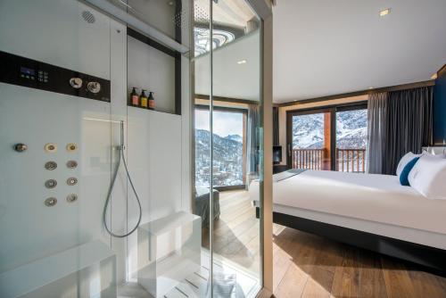 布勒伊-切尔维尼亚冰雪王子酒店的一间卧室设有一张床和一个玻璃淋浴间