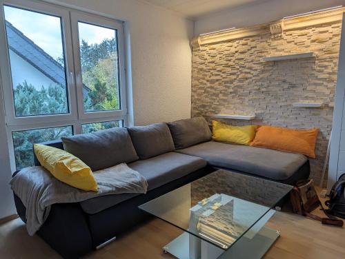 罗斯多夫Ruhige, moderne Wohnung bei Darmstadt in Roßdorf的带沙发和玻璃桌的客厅