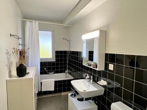 巴塞尔Gemütliche Wohnung Nähe Uni的黑白浴室设有水槽和浴缸。