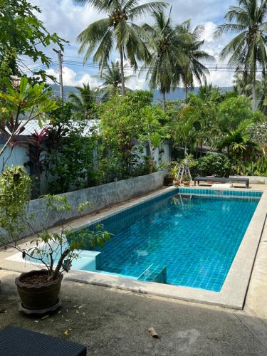 拉迈Villa Roland的棕榈树度假村内的游泳池