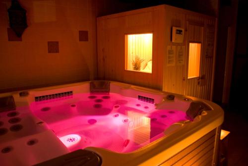 Braojos de la SierraLa Erilla的浴室内带粉红色照明的大型热水浴池