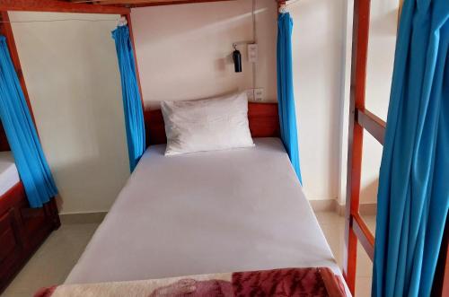 大叻卡姆里民宿的配有蓝色窗帘的小客房内的双层床