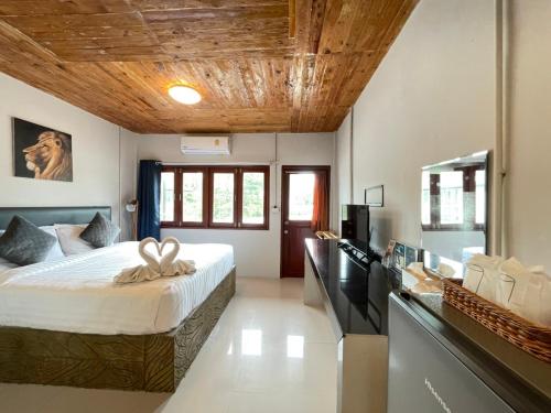 班柯木MOOK BOONCHU HOTEL的一间卧室设有一张带木制天花板的大床