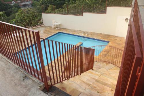 阿瓜斯迪林多亚apartamento águas de lindoia itaigara的游泳池在围栏后方的顶部景色