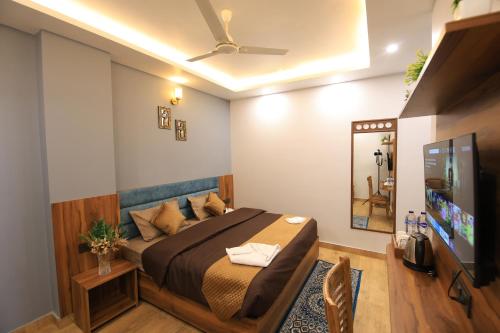 瑞诗凯诗Hotel Mahadev Rishikesh的一间卧室配有一张床和一台平面电视