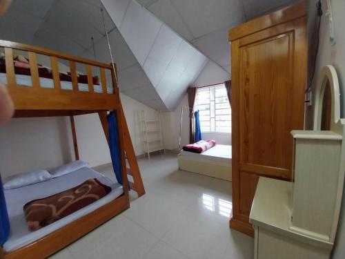 大叻卡姆里民宿的一间带两张双层床的卧室和一间浴室