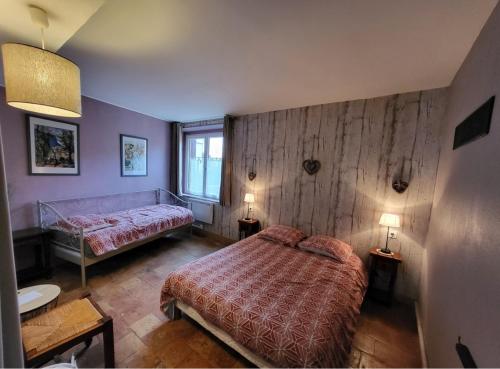 Gréez-sur-RocLa Gouline的一间卧室配有一张床、两张桌子和两盏灯。