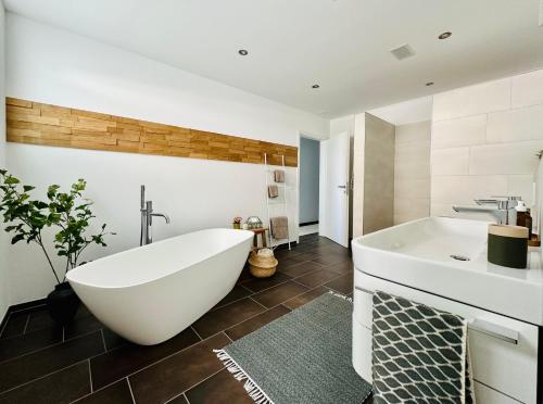 ErmatingenHaus am Bodensee mit Sicht - Stilvoller Luxus的浴室配有大型白色浴缸和水槽