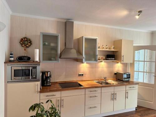 萨斯尼茨Ferienwohnung Seerose的一间大厨房,配有白色的橱柜和水槽