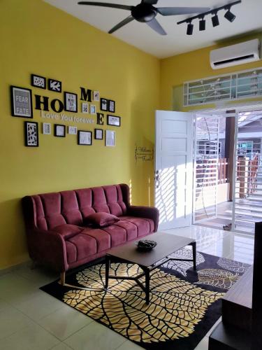 马六甲Amani Homestay的客厅配有红色的沙发和桌子