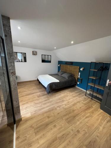 La Tour Carrée的一间卧室配有一张床,铺有木地板