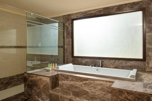 马特鲁港Jaz Oriental, Almaza Bay的带浴缸和玻璃淋浴间的浴室。