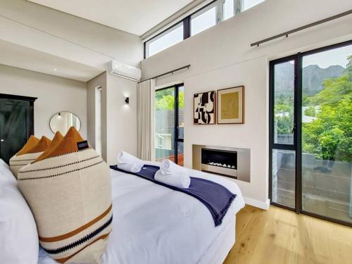 开普敦Luxurious Family home in Newlands with Pool的一间卧室设有一张大床和一个壁炉