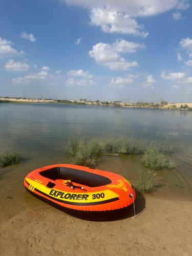 迪拜Oasis Caravan的坐在湖岸上的橘色小船