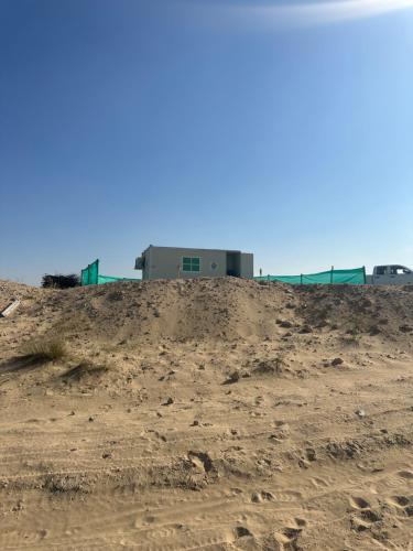迪拜Oasis Caravan的泥土山顶上的建筑物