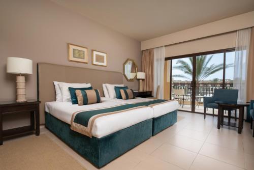 马特鲁港Jaz Oriental, Almaza Bay的酒店客房设有一张床和一个大窗户