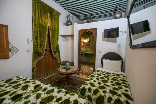 非斯Riad Les Idrissides的一间卧室配有一张床、一张桌子和一面镜子