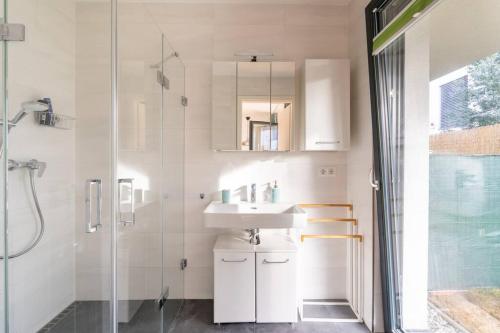 维也纳Luxury Garden apartment near Lake and VIC的白色的浴室设有水槽和淋浴。