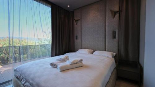 萨卡里亚Velour Hotel Spa Restaurant的一间卧室配有一张大床和毛巾