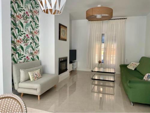科尔多瓦Casa Muralla del Alcazar Viejo的客厅配有绿色沙发和椅子
