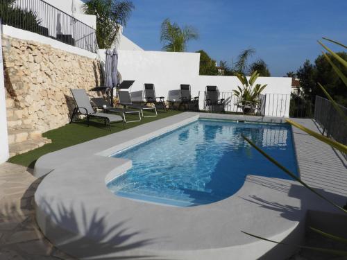 贝尼萨Casa Andamar的院子里的游泳池周围设有椅子