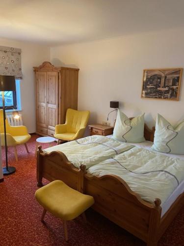 奥泊维森塔尔Neues Haus - Berggasthof und Hotel的一间卧室配有一张床和两张黄色椅子