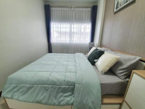 芭堤雅市中心ไอโฮมพัทยาเพลส的一间卧室设有一张大床和一个窗户。