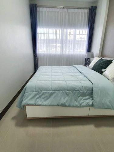 芭堤雅市中心ไอโฮมพัทยาเพลส的一间卧室设有一张大床和窗户