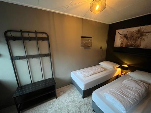 柯德科克Appartement De Zeebries Koudekerke的卧室配有两张床,墙上挂着一幅画