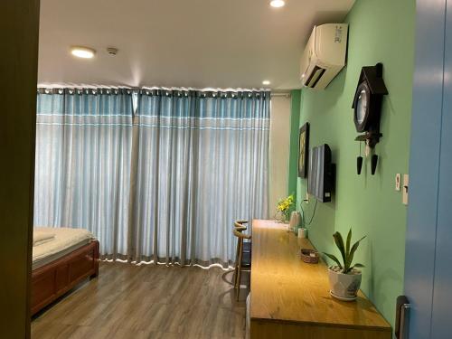 顺安Red Bean Hotel的一间卧室设有绿色的墙壁、一张床和一张书桌