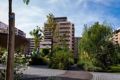 布拉索夫JAD - Luxury - 3 Room Apartments - Urban Plaza的一座有树木和建筑的庭院