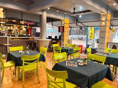巴加Baga beach front的用餐室配有桌子和黄色椅子