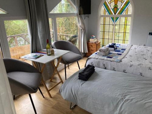 兰达西尔Honey Bee Cabin的卧室配有一张床和一张桌子及椅子