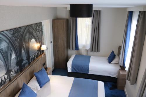 圣米歇尔山特拉斯布拉德酒店的酒店客房带两张床和两个窗户