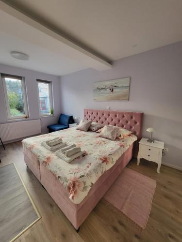 萨格勒布Villa Vino & Grad的一间卧室配有一张带粉红色床头板的大床