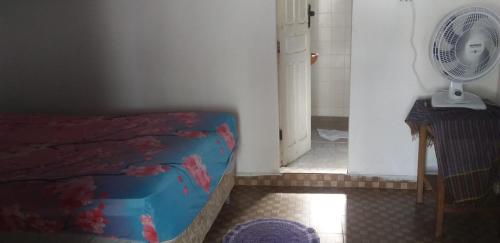 贝伦Residence Girassol的隔壁的房间设有一张床和一个风扇