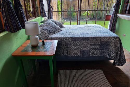圣佩德罗拉拉古纳Sweet little cottage at Lake La Laguna的一间卧室配有一张床和一张带台灯的桌子